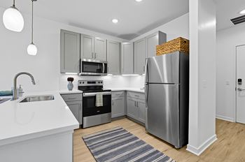 A modern kitchen with stainless steel appliances and white countertops.